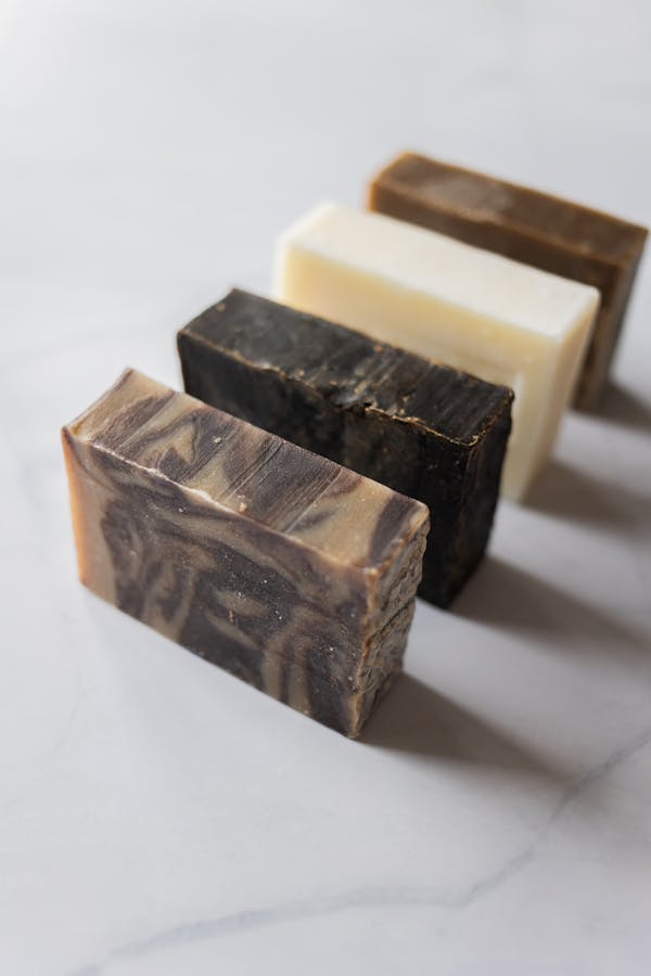 Collection of natural handmade soap bars displayed on a marble surface.