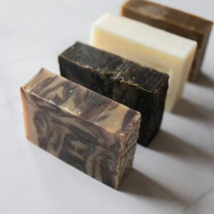 Collection of natural handmade soap bars displayed on a marble surface.
